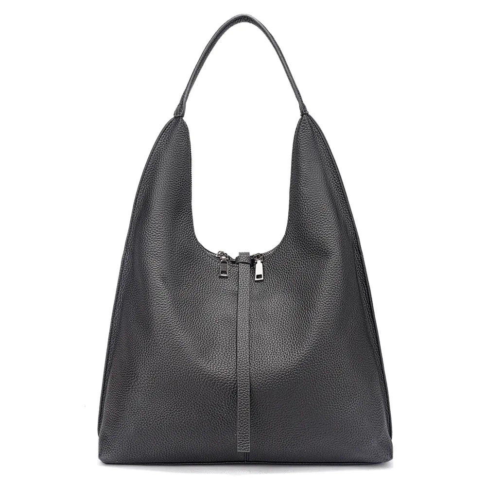 Bolsa tote feminina preta em couro legítimo usada pela modelo, mostrando proporção e caimento no ombro