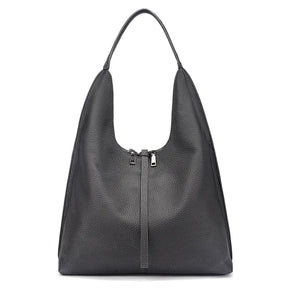 Bolsa tote feminina preta em couro legítimo usada pela modelo, mostrando proporção e caimento no ombro