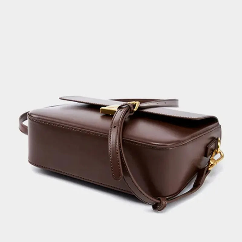Bolsa transversal de couro prestige em vista lateral, com profundidade, alça e acabamento visíveis, sobre fundo claro