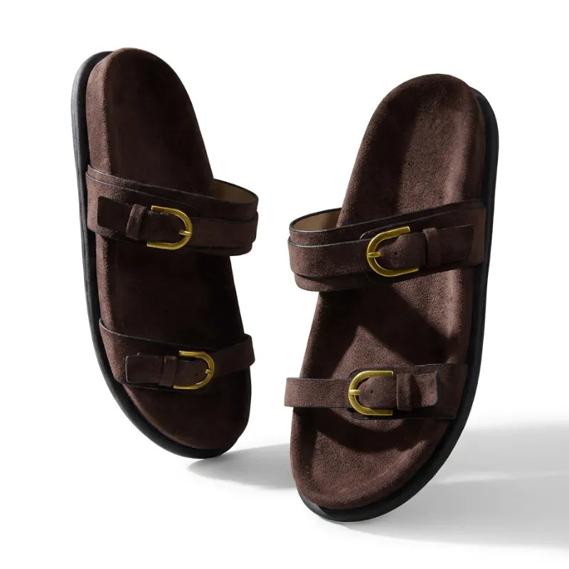 Papete feminina em veludo castanho com duas tiras e fivelas douradas, palmilha anatômica marrom, vista frontal.
