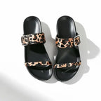 Papete preta com detalhe animal print em vista superior, mostrando palmilha, tiras e formato do bico, sobre fundo claro