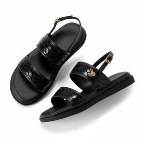 Papete feminina preta com solado flatform, três tiras ajustáveis com fivelas metálicas, vista lateral diagonal.