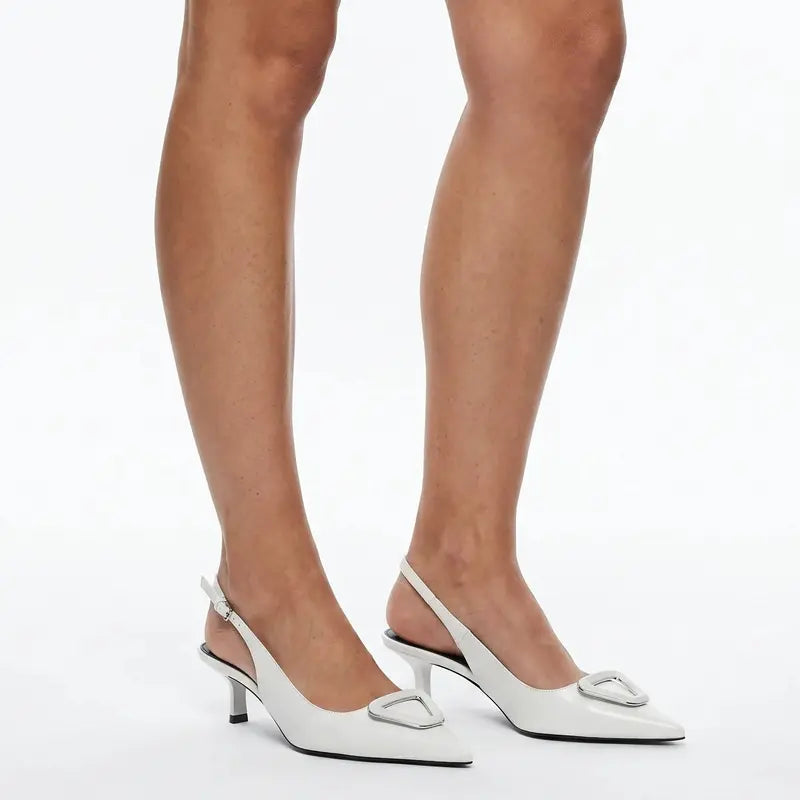 Scarpin branco slingback salto baixo geométrico nos pés da modelo em vista frontal, mostrando ajuste e proporção