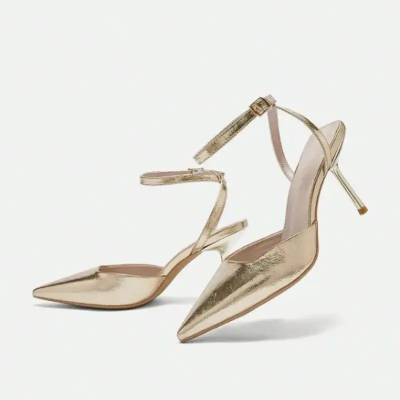 Scarpin dourado slingback bico fino em vista frontal, com bico, tiras e formato do par visíveis, sobre fundo claro