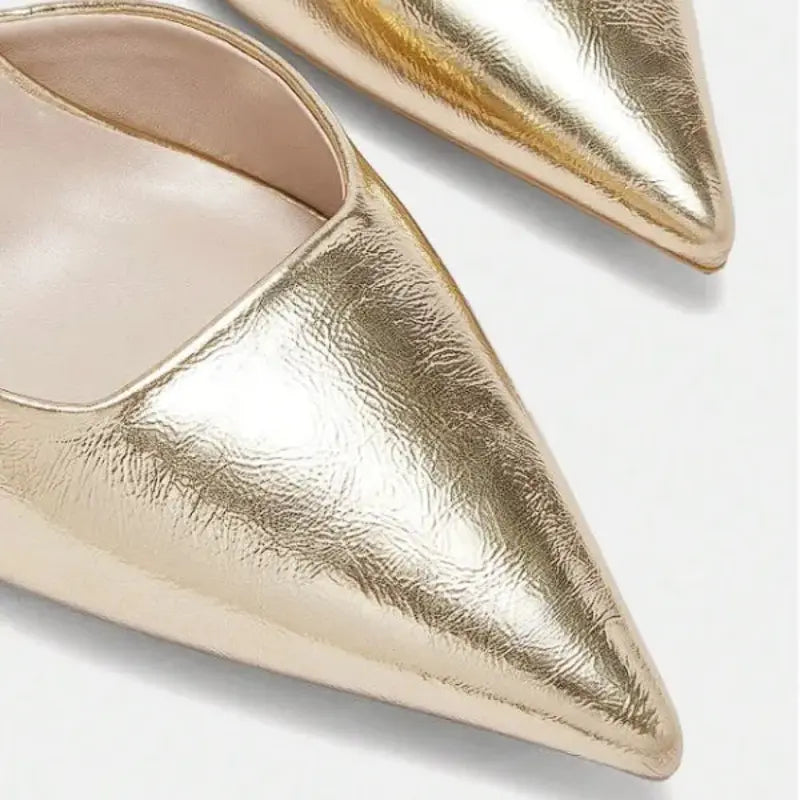 Scarpin dourado slingback bico fino em vista superior, mostrando palmilha, tiras e formato do bico, sobre fundo claro