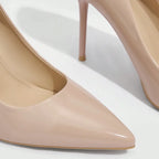Scarpin nude fino salto alto em close no bico, tiras ou fivela, com textura e metal em destaque, sobre fundo claro