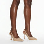 Scarpin nude salto slingback sophie nos pés da modelo em vista lateral, destacando perfil e altura, sobre fundo claro