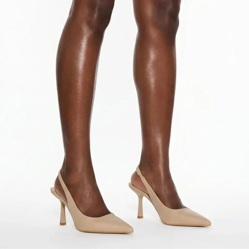 Scarpin nude salto slingback sophie nos pés da modelo em vista lateral, destacando perfil e altura, sobre fundo claro