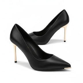 Scarpin preto fosco salto alto dourado em perspectiva diagonal, com formato, material e salto visíveis, sobre fundo claro