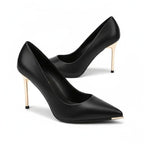 Scarpin preto fosco salto alto dourado em perspectiva diagonal, com formato, material e salto visíveis, sobre fundo claro