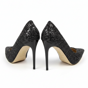 Scarpin preto salto alto com glitter em vista frontal, com bico, tiras e formato do par visíveis, sobre fundo claro