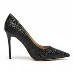 Scarpin preto salto alto com glitter em vista lateral, com bico e perfil do salto ou solado visíveis, sobre fundo claro