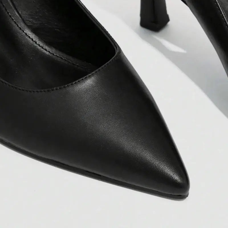 Scarpin preto slingback bico fino em vista superior, mostrando palmilha, tiras e formato do bico, sobre fundo claro