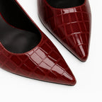 Scarpin slingback croco marsala salto agulha em vista frontal, com bico, tiras e formato do par visíveis