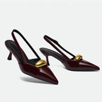 Scarpin slingback marsala detalhe dourado em ângulo três-quartos, mostrando o par, o bico e o perfil lateral