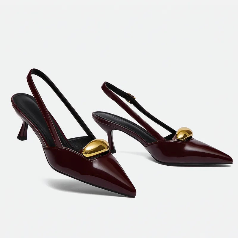 Scarpin slingback marsala detalhe dourado em ângulo três-quartos, mostrando o par, o bico e o perfil lateral