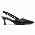 Scarpin slingback preto croco detalhe dourado em vista lateral, com bico e perfil do salto ou solado visíveis