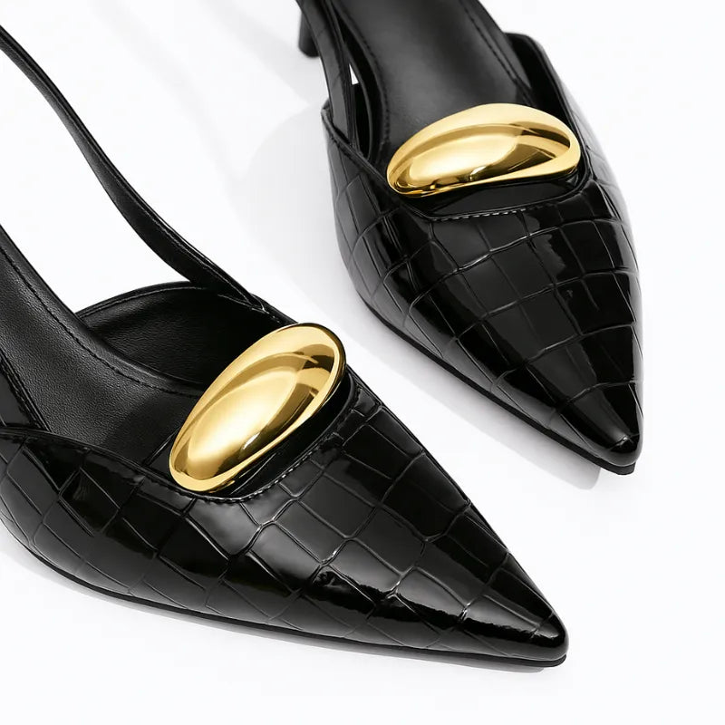 Scarpin slingback preto croco detalhe dourado em close no bico, tiras ou fivela, com textura e metal em destaque