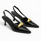 Scarpin slingback preto croco detalhe dourado em ângulo três-quartos, mostrando o par, o bico e o perfil lateral