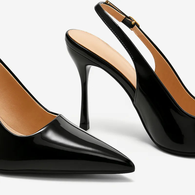 Scarpin slingback preto salto agulha em close no bico, tiras ou fivela, com textura e metal em destaque