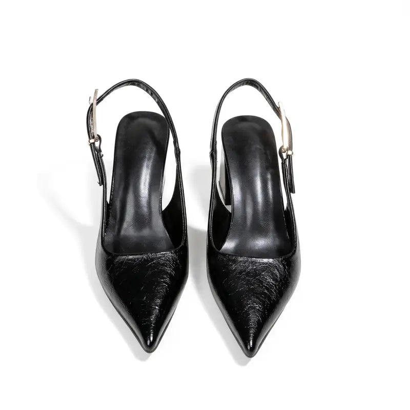 Close do scarpin slingback preto com bico fino, evidenciando o cabedal em couro PU e o formato alongado do calçado.