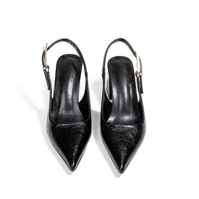Close do scarpin slingback preto com bico fino, evidenciando o cabedal em couro PU e o formato alongado do calçado.