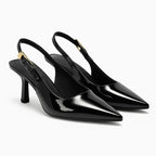 Scarpin preto slingback salto médio em ângulo três-quartos, mostrando o par, o bico e o perfil lateral, sobre fundo claro