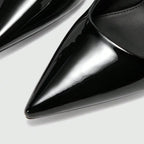 Scarpin preto slingback salto médio em detalhe frontal, destacando bico fino, verniz e acabamento do material