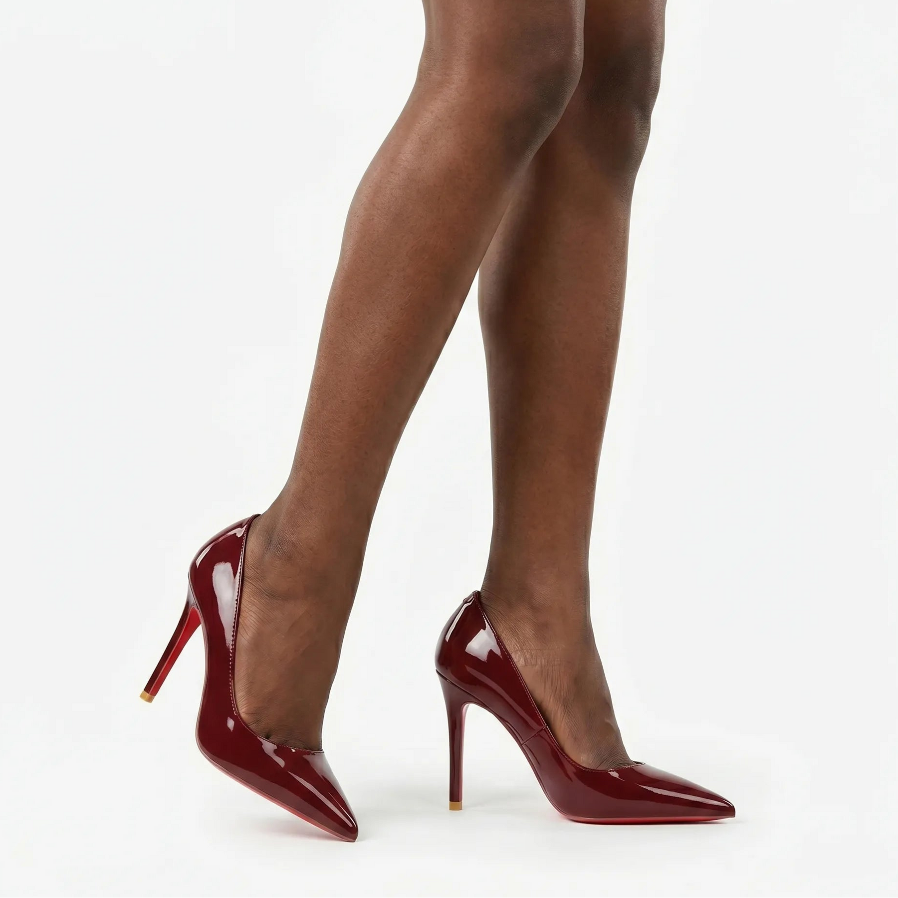 Scarpin vinho em verniz feminino com bico fino e salto alto, sola vermelha característica, modelo em pé vista lateral destacando brilho elegante e acabamento sofisticado.