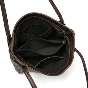 Bolsa hobo vintage marrom café aberta por cima, com forro, espaço interno e fechamento visíveis, sobre fundo claro